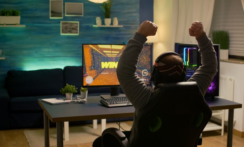 videogamer player raising hands after winning first person shooter